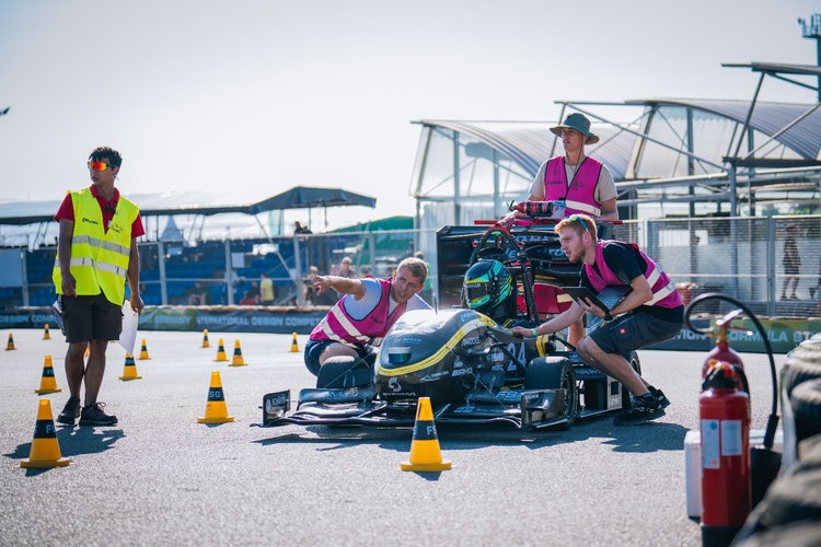 Das Formula-Student-Team KA-RaceIng erklärt seinem Rennfahrer den Ablauf der nächsten Disziplin auf Hockenheim. © Formula Student Germany/Tim Schulte