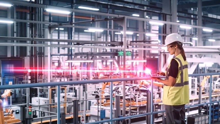 Frau mit Tablet in Fabrikhalle