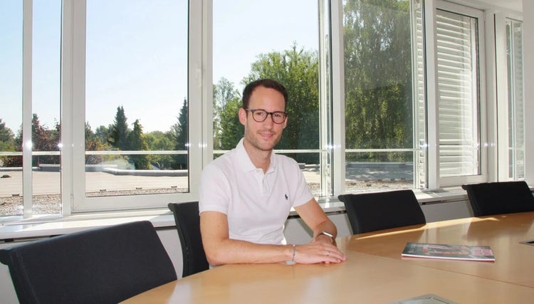 Simon Budde, Koodinator vom Eplan Partner Network, sitzt an Konferenztisch.