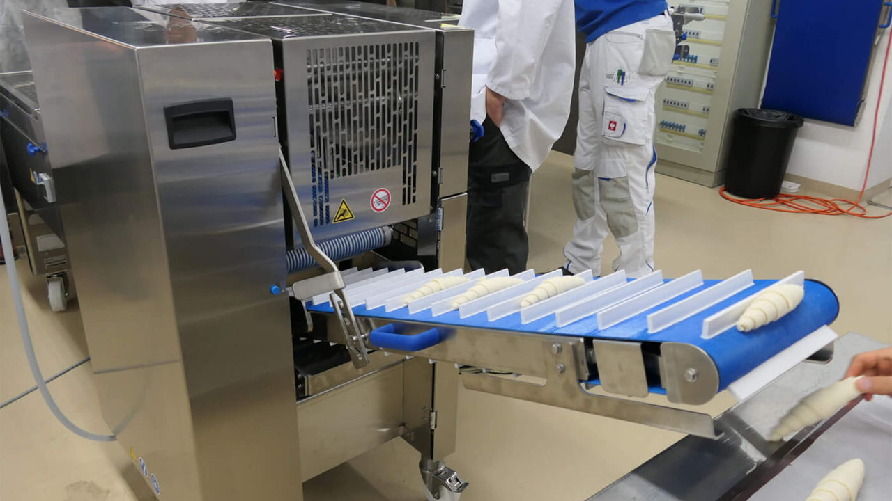 Der Teig wird für die Croissants automatisiert geschnitten und gerollt