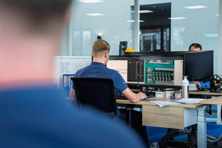 Afbeelding met overdekt, Kantoorgebouw, persoon, computerbeeldscherm Door AI gegenereerde inhoud is mogelijk onjuist.