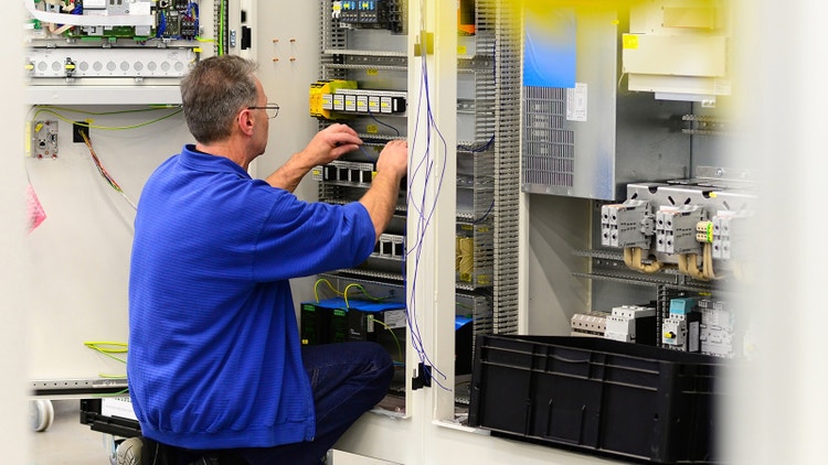 Paneelbouwer bezig met een paneel in een kast bedraden